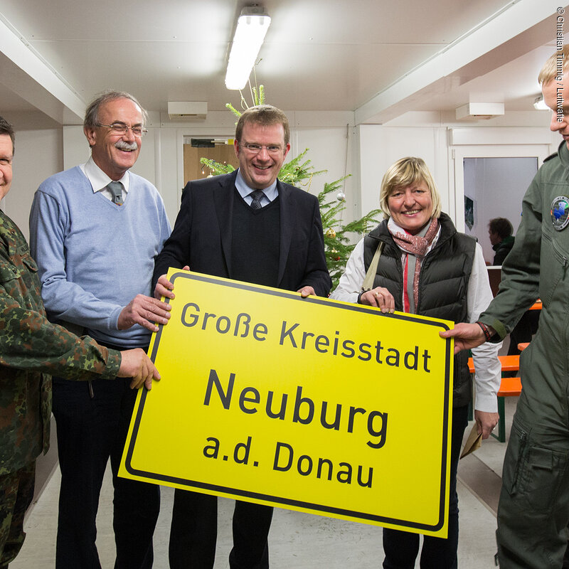 Ämari Air Base, Estland, 12. Dezember 2016 -  Besuch beim Deutschen Kontingent Verstärktes Air Policing Baltikum (VAPB) durch den Inspekteur der Luftwaffe, Generalleutnant Karl Müllner. Ein Gruß aus der Heimat Generalleutnant Karl Müllner, Bgm Dr. Rüdiger Vogt, MdB Reinhard Brandl, LRin Sabine Schneider und Kontingentführer Oberstleutnant Johannes Durand (v.l.) mit dem Ortschild aus Neubrug. Foto: Christian Timmig / Luftwaffe